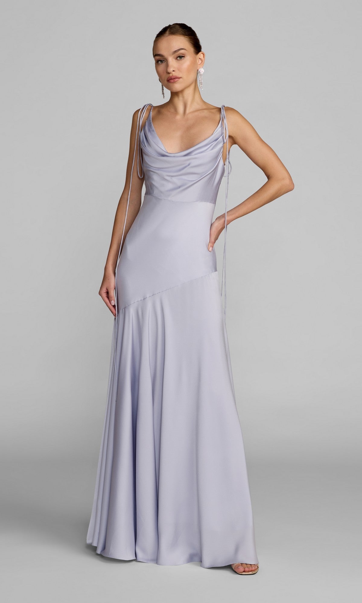 A woman stands in a floor-length, powder blue formal dress—Mac Duggal 49914—with a draped cowl neckline and thin straps, posing against a plain gray background.